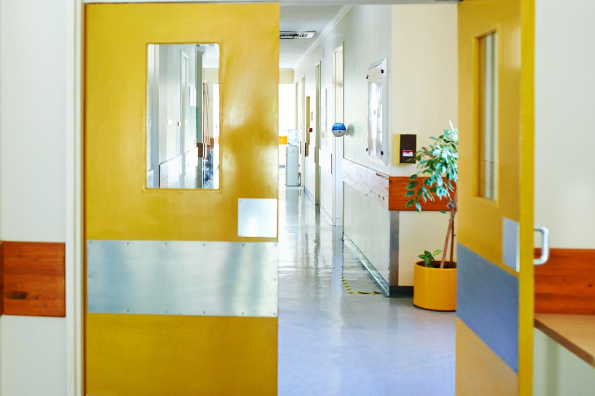 Door from a hospital room opening to a hallway.